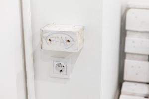 un enchufe blanco con un perro. en Junior Tower Apartment, en Budapest