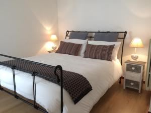 ヴィテルボにあるLulù Bed & Dreamsのベッドルーム(白黒のベッド1台、ランプ2つ付)