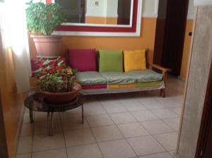 アナーニにあるAlbergo Ristorante Bar FEDERICOのカラフルな枕付きのソファが備わる客室です。