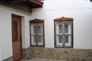 three windows on the side of a house at Guest House Vodolei in Kotel