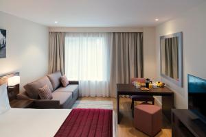 una camera d'albergo con letto, divano e tavolo di Marlin Waterloo a Londra