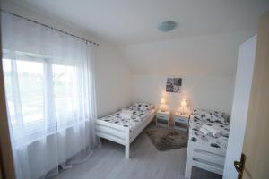 a room with two beds and a window at Apartman Mm in Slavonski Brod