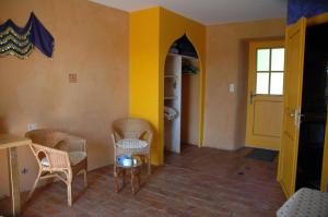 una stanza con sedie e tavolo e una porta gialla di La Jameliniere a Chailland