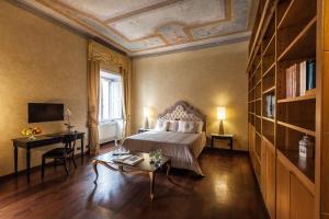 ローマにあるPrestigious Apartment Piazza Navonaのベッドルーム1室(ベッド1台、テーブル、デスク付)