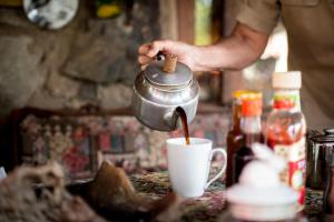Facet wlewa kawę do kubka. w obiekcie Rio Dos Elefantes River Camp w mieście Hoedspruit