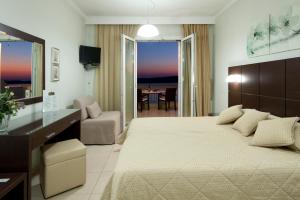 a bedroom with a large bed and a living room at Hotel Anezina in Pylos