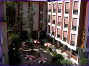 a large building with a patio with umbrellas at Hotel 5 Terre in Monterosso al Mare