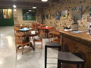 a restaurant with wooden tables and chairs and a bar at Balneario Acuña in Caldas de Reis