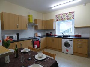 a kitchen with a table and a washing machine at West Lea House in Chesterfield