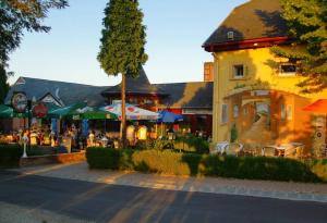 een gebouw met tafels, stoelen en parasols bij Polgármester Étterem és Panzió in Fertőszéplak