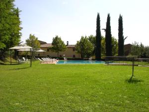 einen Hof mit Pool und Bäumen und ein Haus in der Unterkunft Appartamenti Avanella a 150 mt dalla piscina 150 mt from swimming pool in Certaldo