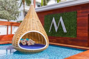 a wicker chair sitting on top of a swimming pool at Marseilles Beachfront Hotel in Miami Beach