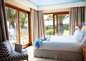 a bedroom with a bed and a window with a laptop at Gecko Hotel & Beach Club, a Small Luxury Hotel of the World in Playa Migjorn