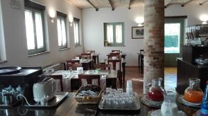 a dining room with tables and chairs and windows at Hotel San Claudio in Corridonia