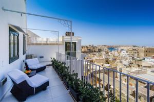 a balcony with chairs and a view of a city at BOCO Boutique Hotel in Cospicua