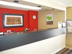 una sala de espera con un mostrador de bienvenida y una pared roja en Extended Stay America Suites - San Jose - Sunnyvale, en Sunnyvale