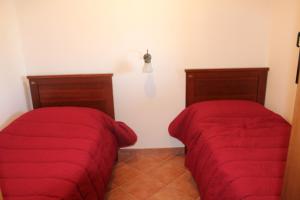 two beds in a room with red blankets at Residence Hotel Torresilvana in Vieste