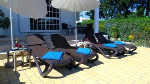 a group of chairs and umbrellas on a patio at 6 Bedroom Private Villa Tenazinha I, with private pool in Albufeira