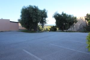 an empty parking lot with trees and a building at Residence Hotel Torresilvana in Vieste