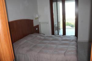 a bedroom with a bed and a door to a balcony at Residence Hotel Torresilvana in Vieste