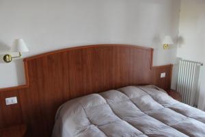 a bed with a wooden headboard in a bedroom at Residence Hotel Torresilvana in Vieste