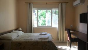 Cama ou camas em um quarto em Coimbra Hotel Pousada