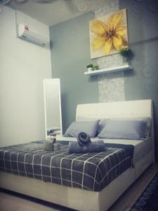 een slaapkamer met een bed met een gele bloem aan de muur bij Fahaz Lumut Homestay in Lumut