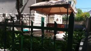 an orange umbrella in front of a fence at Garden apartment Vanya in Split