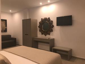 a bedroom with a bed and a mirror and a tv at Golden View Residence in Dhërmi