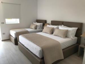 a bedroom with two beds and a window at Golden View Residence in Dhërmi