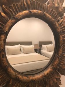 a mirror reflecting a bed in a room at Golden View Residence in Dhërmi