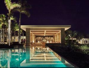 a house with a swimming pool at night at Four Seasons Resort and Residences Anguilla in Meads Bay