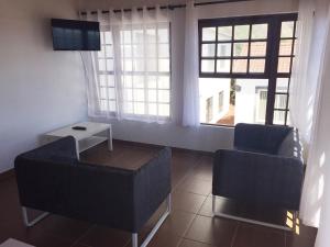 a living room with two chairs and a tv at Residencias Varadouro in Varadouro