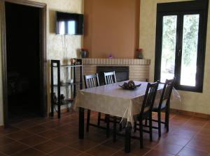 Un comedor con mesa y sillas y chimenea. en Alojamiento Rural El Chaparral, en Setenil