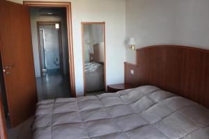 a bedroom with a large bed and a bathroom at Residence Hotel Torresilvana in Vieste