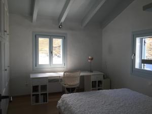 a bedroom with a bed and a desk and two windows at Seaside Heaven in Otziás
