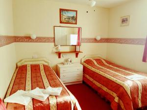 Un pat sau paturi într-o cameră la Malvern Hotel