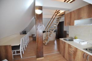 a kitchen with a sink and a staircase in a room at Dobricin Konak Apartmani in Kopaonik