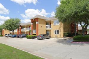 a apartment building with cars parked in a parking lot at Extended Stay America Suites - Arlington in Arlington