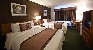 ArcadiaDraft Horse Inn and Suites的一间有两张床和一台平板电视的酒店房间