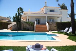 a villa with a swimming pool in front of a house at Casa Clementina in Lagos