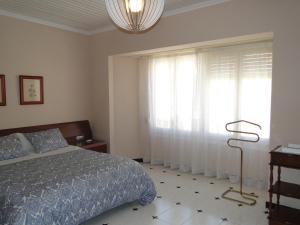 a bedroom with a bed and a large window at Cal Marsal in Aitona