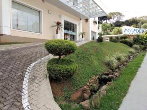 a house with a bush on the side of a road at Hotel Aguadero in Passo Fundo