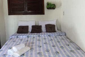 a bed with two towels and pillows on it at Pousada Barra do Mundaú in Lavagem