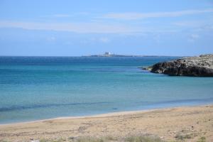 a view of the ocean from a sandy beach at Appartamento al mare, Isola blu in Marzamemi