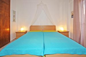 a bedroom with a large blue bed with two night stands at Villa Angela in Vourvourou