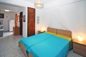 a bedroom with a blue bed and a kitchen at Villa Angela in Vourvourou