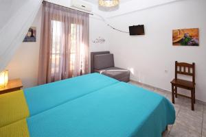 a bedroom with a blue bed and a chair at Villa Angela in Vourvourou