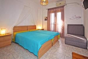 a bedroom with a bed and a chair in it at Villa Angela in Vourvourou