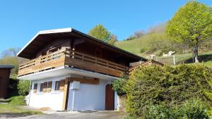 a small house on a hill with cows in the background at les Genêts in La Bresse